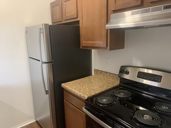 A kitchen with a stainless steel refrigerator and stove
